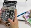 Persona con calculadora en mano haciendo la cuenta de cuánto le deberán pagar por su recargos dominicales. FOTO: EL COLOMBIANO