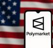 De fondo, la bandera de Estados Unidos, y de frente, un celular con la aplicación de Polymarket. FOTO: GETTY