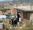 Adelante, parte del material que fue incautado y destruido por las autoridades. Atrás, una de las viviendas ilegales que se alzan en la zona. FOTO: Cortesía