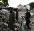 Residentes locales permanecen sobre los escombros de las estructuras destruidas en Pakistán. Foto: AFP