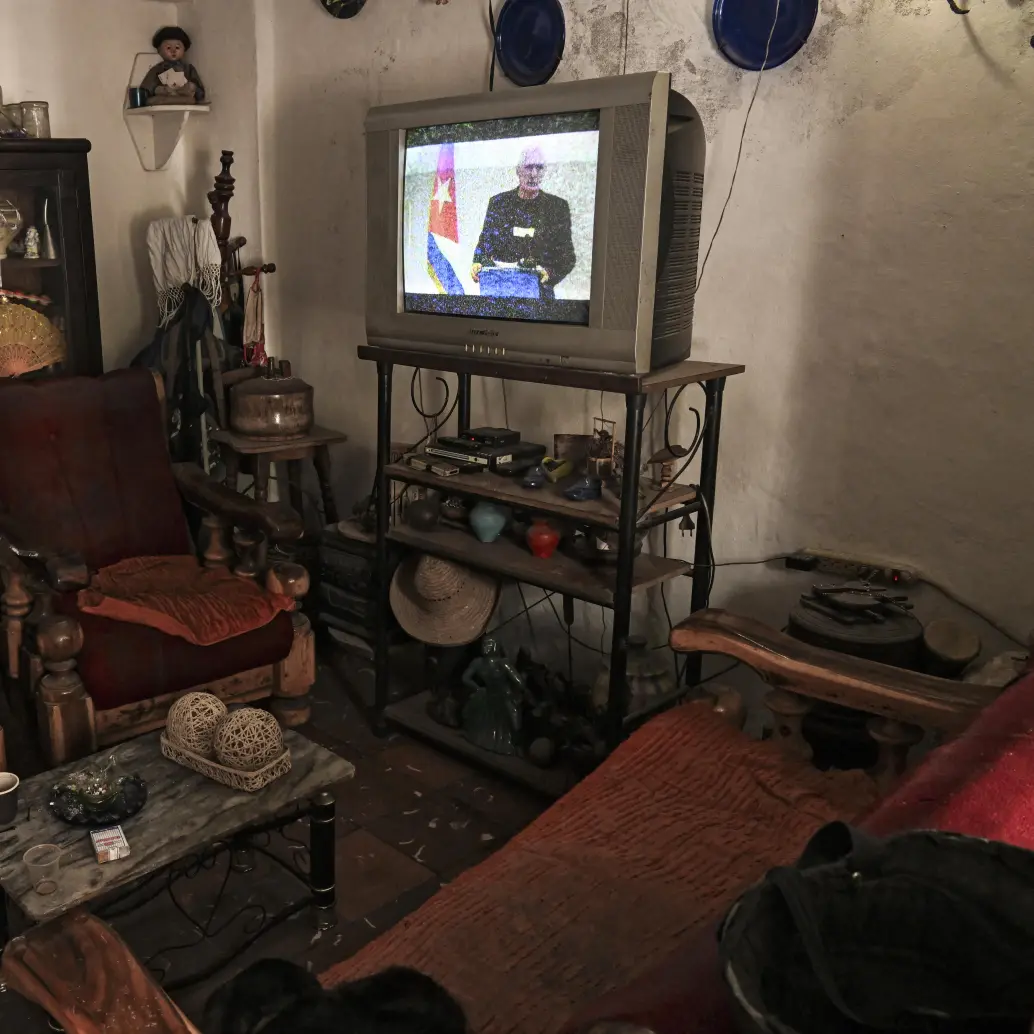 Una mujer escucha al presidente de Cuba, Miguel Díaz-Canel, hablar en la televisión nacional desde su casa en La Habana el 5 de febrero de 2026. Aquí se anunció que el régimen de la isla está dispuesto a entablar diálogo con Estados Unidos, pero no bajo presión. Foto: Yamil Lage / AFP