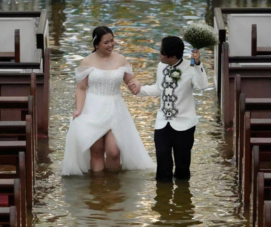 La pareja caminando en el agua en la iglesia donde se casaron. FOTO: Tomada de redes sociales
