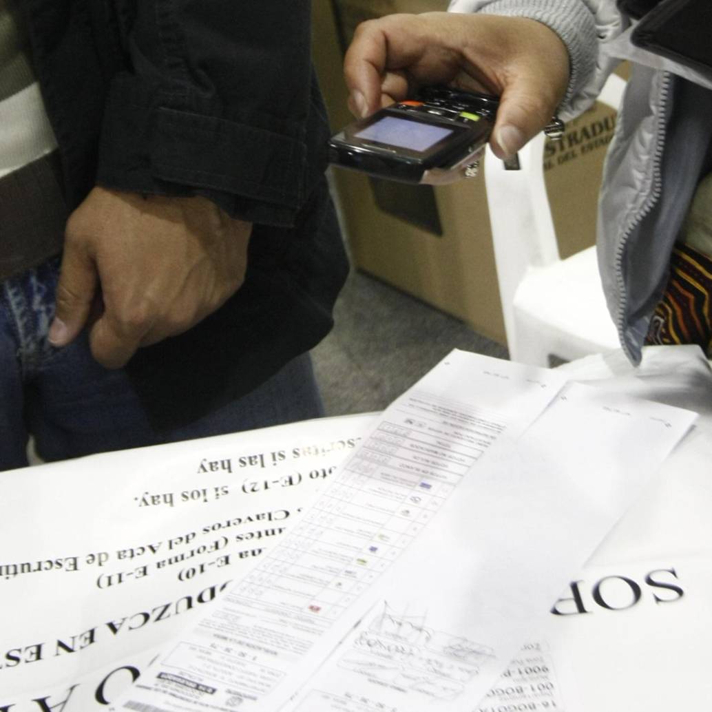 Testigo electoral toma una fotografía del formulario E-14 con su celular. Foto: Colprensa - Christian Castillo