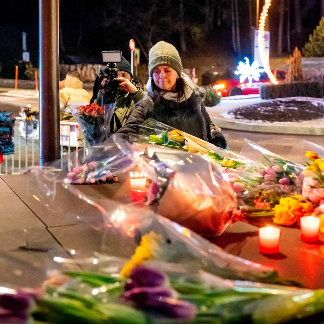 Una mujer pone flores cerca del lugar donde un incendio arrasó un bar abarrotado durante las celebraciones de Nochevieja en la ciudad de Crans-Montana. FOTO: AFP