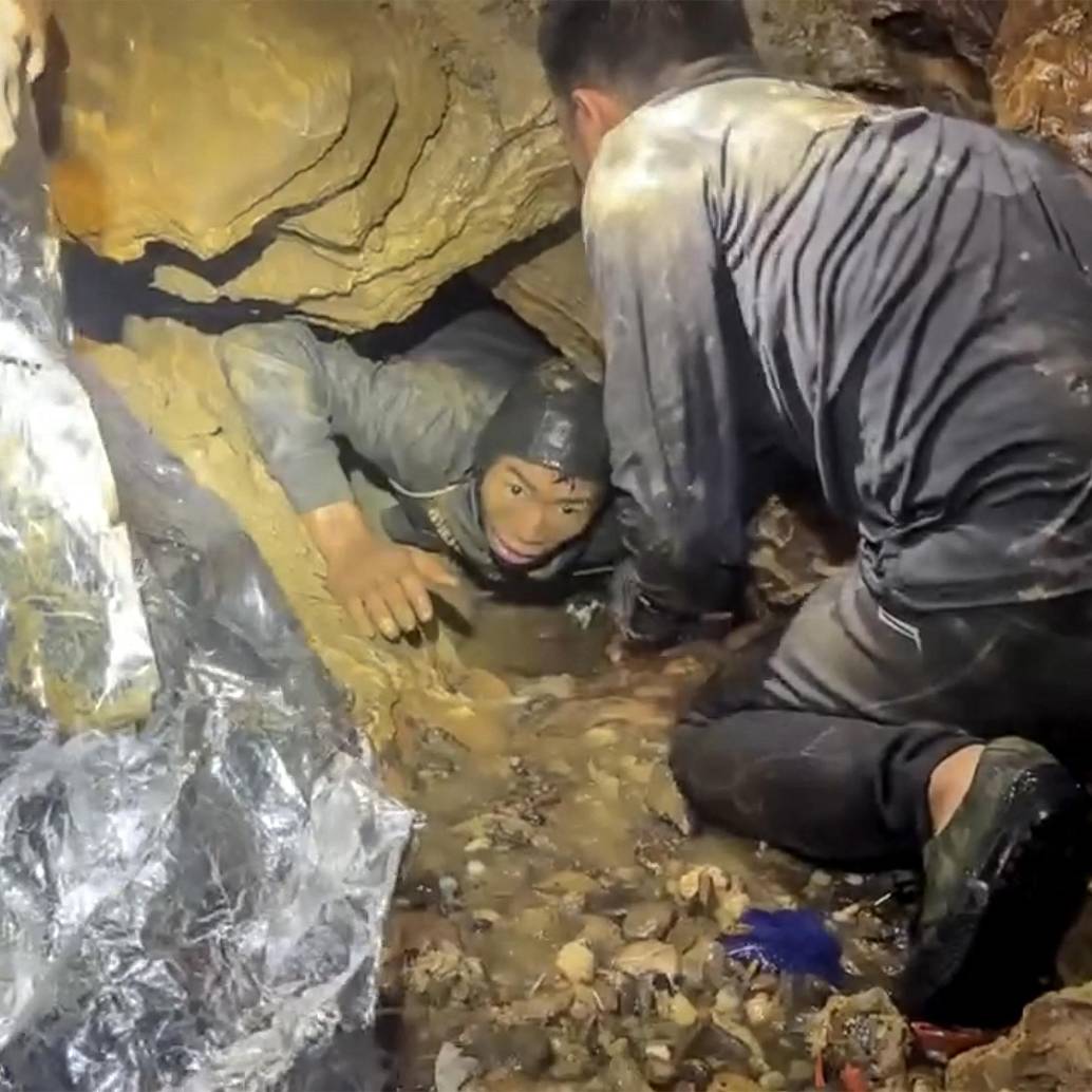 Esta es una captura de pantalla tomada de un video facilitado el 29 de mayo de 2026 por Metta Tham Rescue Kalasin y muestra a un equipo de rescate liberando a uno de los siete hombres (izquierda) atrapados en una cueva semisumergida en la provincia central de Xaysomboun, al noreste de la capital, Vientiane. Foto: AFP