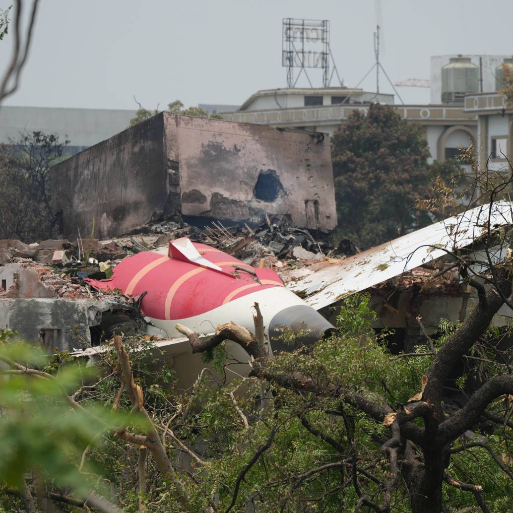 Personas permanecen junto a los restos del accidente aéreo de Air India, en Ahmedabad del estado de Gujarat, en el oeste de India, el 13 de junio de 2025. El Gobierno indio ha iniciado una investigación formal sobre el trágico accidente aéreo de Air India ocurrido el jueves, confirmó el viernes el ministro de Aviación Civil del país, Ram Mohan Naidu, en una publicación en las redes sociales. Imagen tomada de agencia Xinhua 