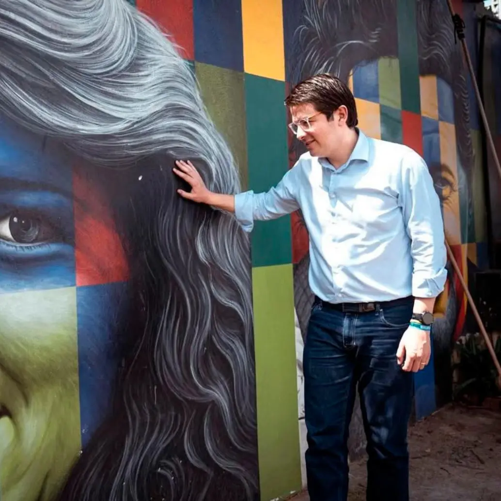 Miguel Uribe junto a un mural de su madre, Diana Turbay, en Bucaramanga. FOTO: Tomada de Instagram @migueluribet