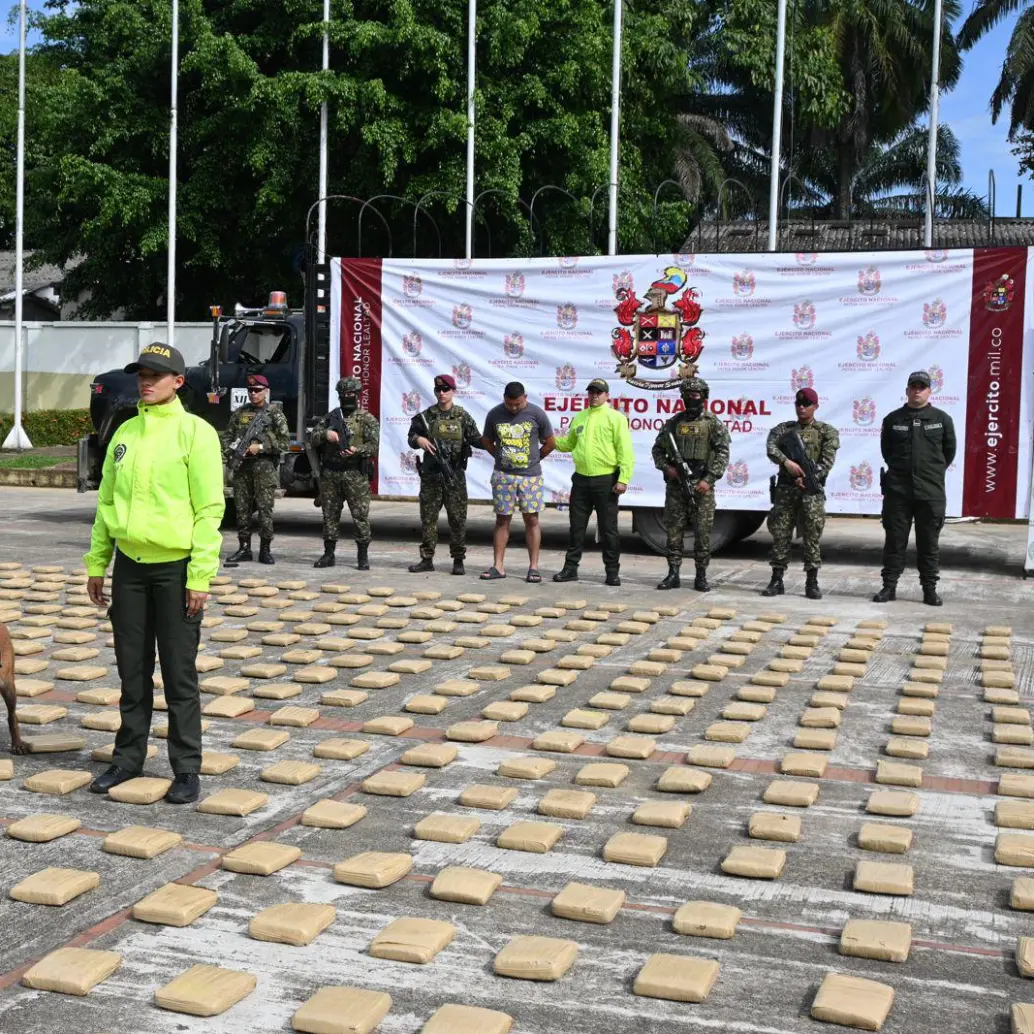 El Ejército junto a uno de los capturados. En el piso, los bloques de droga incautada. FOTO: CORTESÍA
