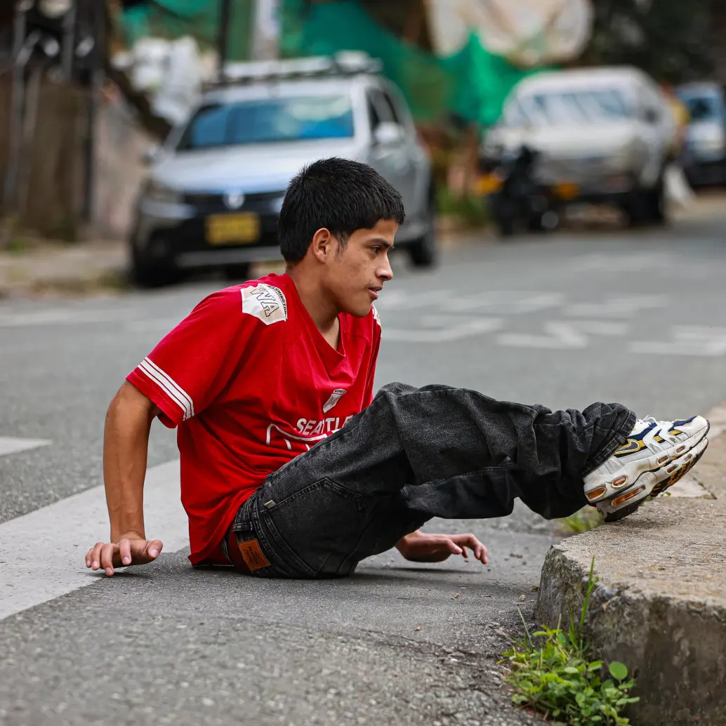 Desde que perdió su silla de ruedas, Matías se desplaza por las calles del corregimiento con la fuerza de sus brazos. Foto: Manuel Saldarriaga. 