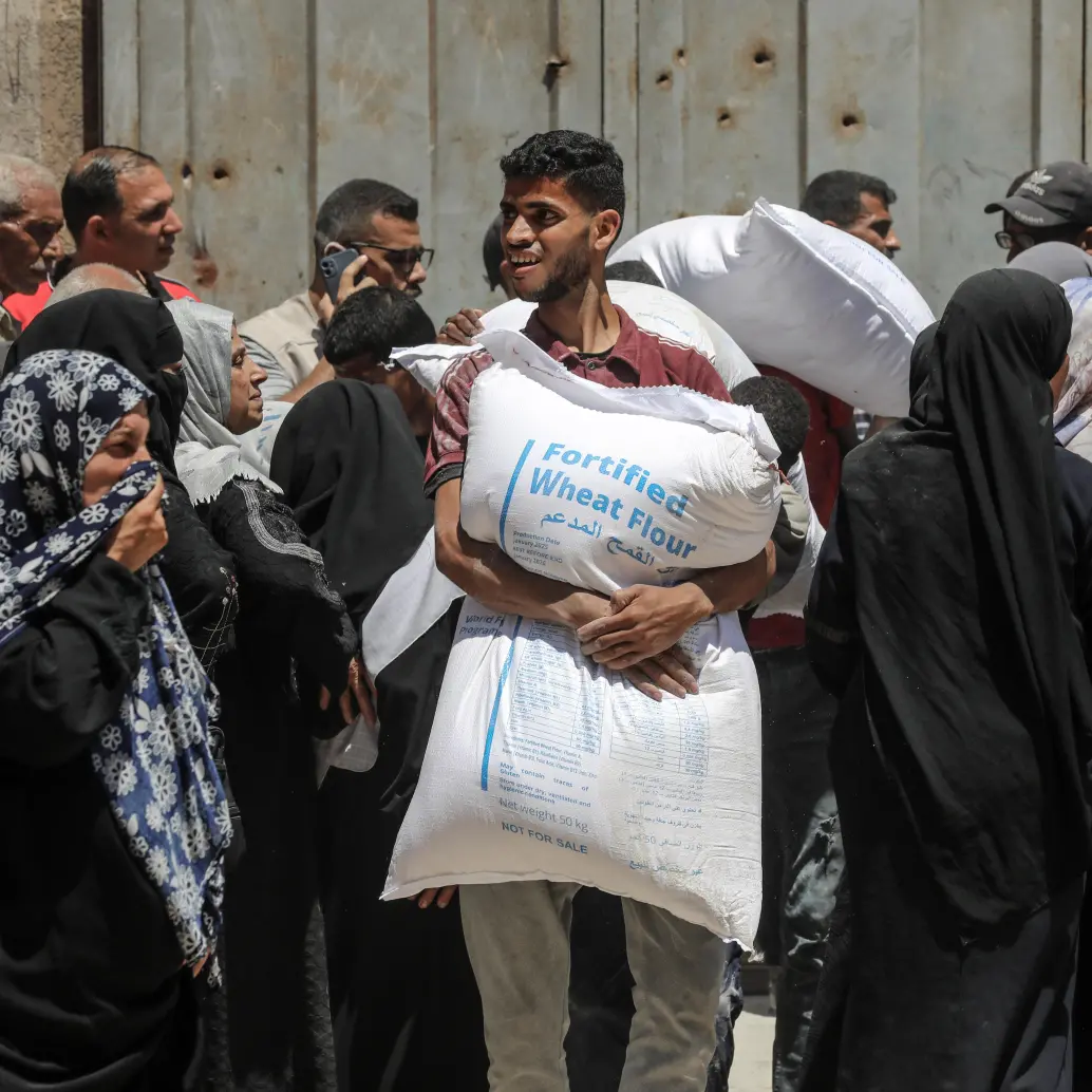 Palestinos se reúnen para recibir ayuda de alimentos en un punto de distribución de asistencia alimentaria, en la Ciudad de Gaza. FOTO: Xinhua