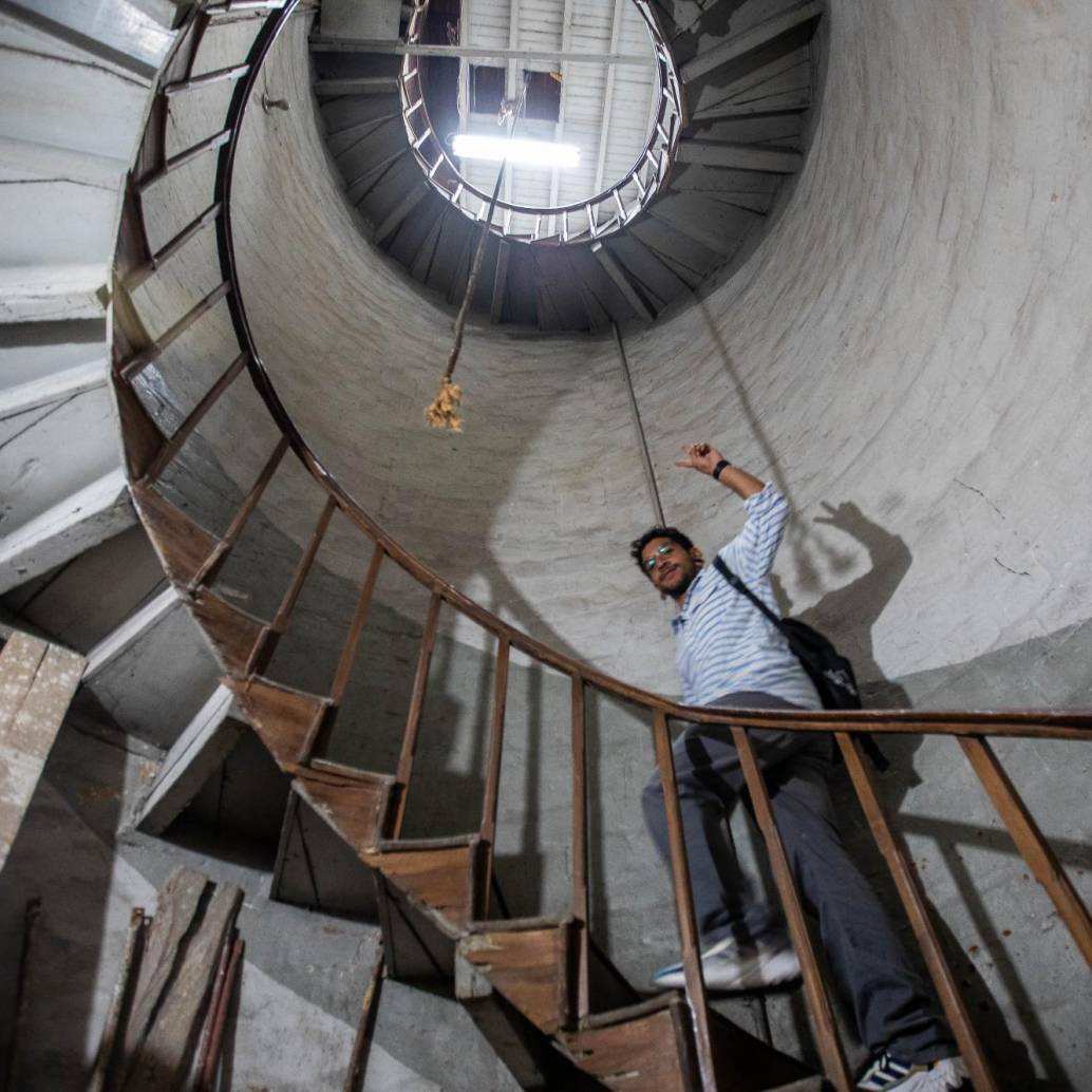Ómar Portela, joven creador de contenido sobre la historia de Medellín, ascendiendo por la escalera de la torre del reloj de la iglesia de Boston. Foto: Esneyder Gutiérrez Cardona