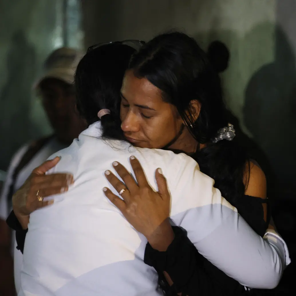 Dos mujeres reaccionan mientras participan en una oración, mientras familiares de presos esperan frente a la cárcel de El Rodeo, en Caracas, el 9 de enero de 2026 Foto: AFP