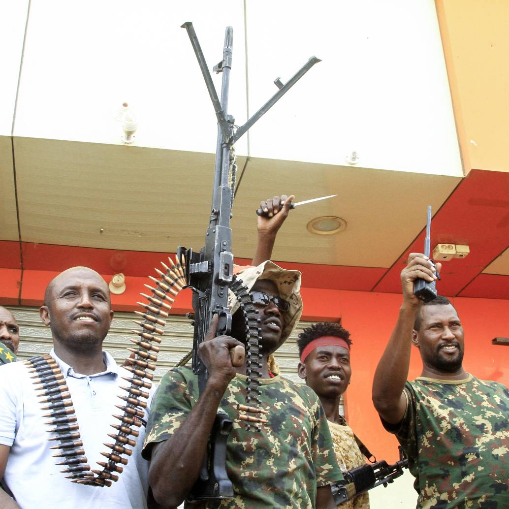 Un hombre posa con soldados del ejército sudanés en Salha, al sur de Omdurman, un día después de haber recuperado la zona de manos de las fuerzas paramilitares de Apoyo Rápido (RSF), el 21 de mayo de 2025. Desde su estallido en 2023, Sudán ha sido devastado por la guerra entre las RSF y el ejército, alimentada por intereses regionales contrapuestos que incluyen a los Emiratos Árabes Unidos, Egipto, Arabia Saudita e Irán. Mercenarios extranjeros han aparecido en ambos bandos del conflicto. (Foto de Ebrahim Hamid / AFP)