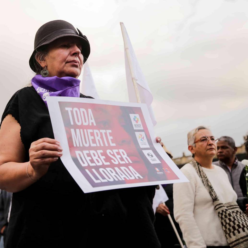 Una mujer sosteniendo una pancarta que dice “toda muerte debe ser llorada”. FOTO: COLPRENSA.