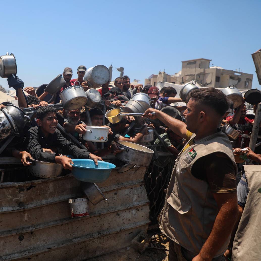 Un grupo de personas en Gaza espera con ollas y recipientes para recibir una ración de comida en medio de la grave escasez de alimentos denunciada por Médicos Sin Fronteras. Foto, Xinhua/Rizek Abdeljawad