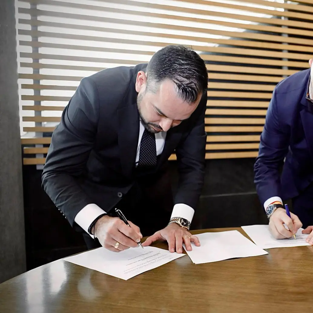 Edwin Palma, ministro de Minas y Energía (izq.), firma acuerdo de confidencialidad con representante de Venezuela por Monómeros. FOTO tomada de X