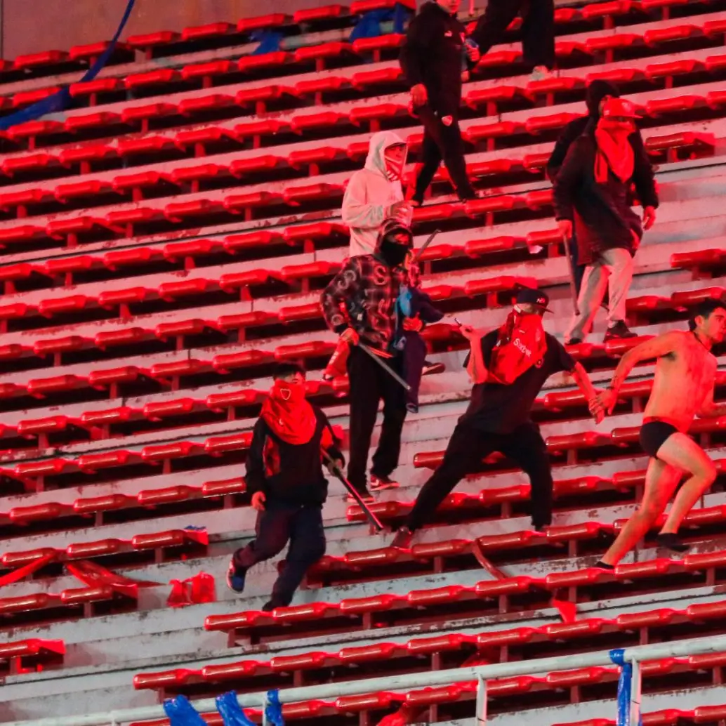 Imágenes de un hincha saltando al vacío y otros siendo agredidos en las gradas circularon después de los enfrentamientos entre fanáticos de Independiente y la U de Chile. FOTO GETTY