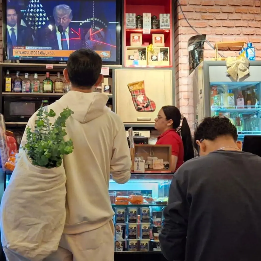 Miles de venezolanos que residen y trabajan en Medellín siguen a través de establecimientos comerciales la captura del dictador Nicolás Maduro. Foto: EL COLOMBIANO