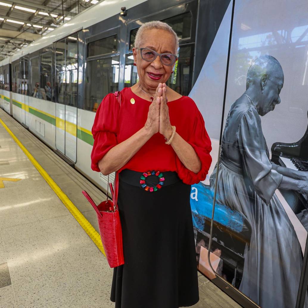 Teresita Gómez posa al lado de su Tren de la Cultura, ese lleno de imágenes suyas y reflexiones para acompañar a los viajeros del Metro de Medellín. FOTO Manuel Saldarriaga. 