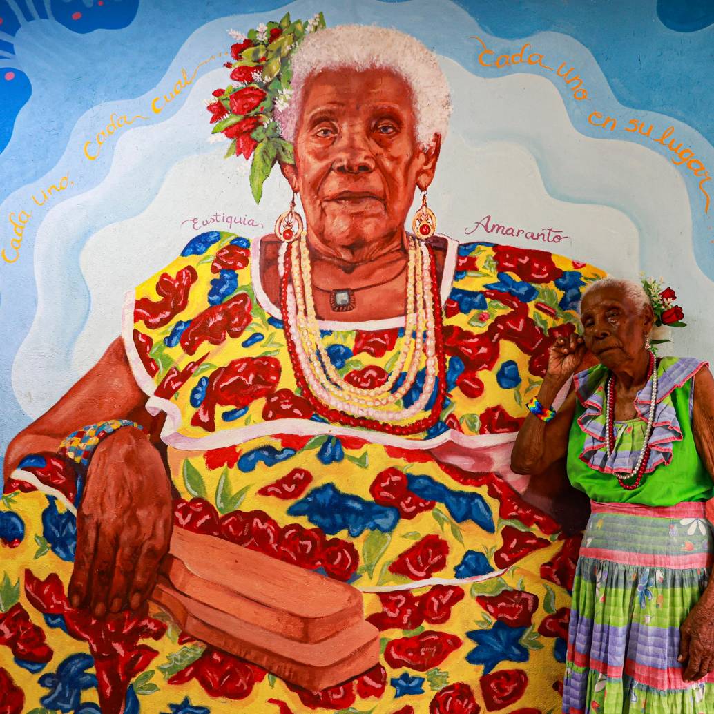 Eustiquia Amaranto Santana junto a un mural con su rostro en su casa ubicada en Turbo. FOTO: MANUEL SALDARRIAGA
