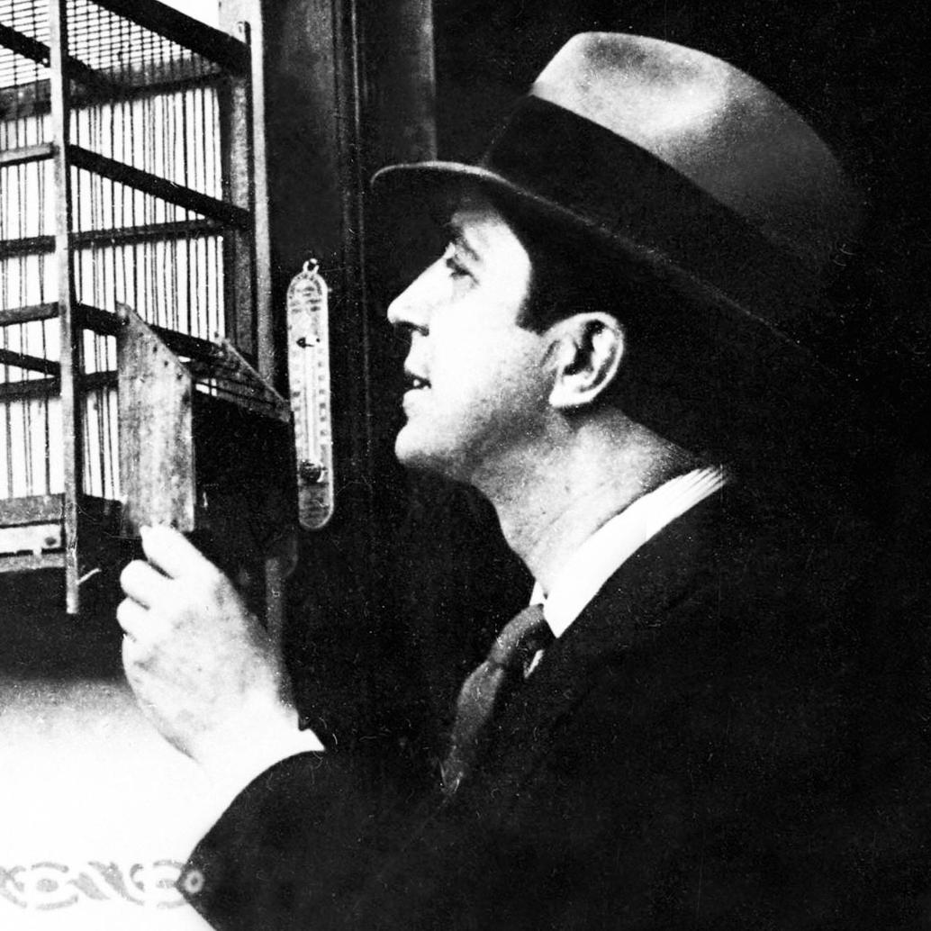 Foto tomada en 1930 muestra al cantante de tango observando un pájaro en una jaula. FOTO AFP