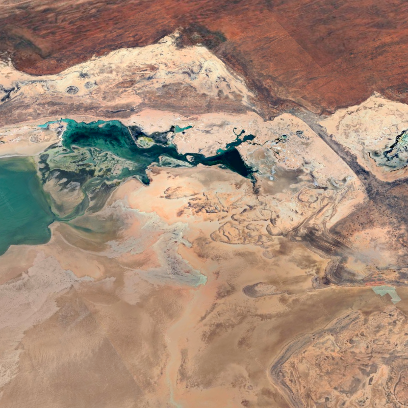 Vista aérea del paisaje desértico en Australia Occidental, capturada por Google Earth, donde contrastan las lagunas turquesa con las formaciones rocosas y los tonos ocres del terreno. FOTO cortesía Google Earth