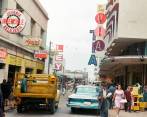 La calle Pichincha, a la altura de su cruce con la carrera Carabobo, fue el epicentro de una revolución comercial que transformó a la Medellín de mediados del siglo XX. Esta foto colorizada por Jossi Barbosa con inteligencia artificial, se utilizó la herramienta Palette. FOTO: CARLOS RODRÍGUEZ - FOTO REPORTER / ARCHIVO DEL CENTRO DE INFORMACIÓN PERIODÍSTICA DE EL COLOMBIANO
