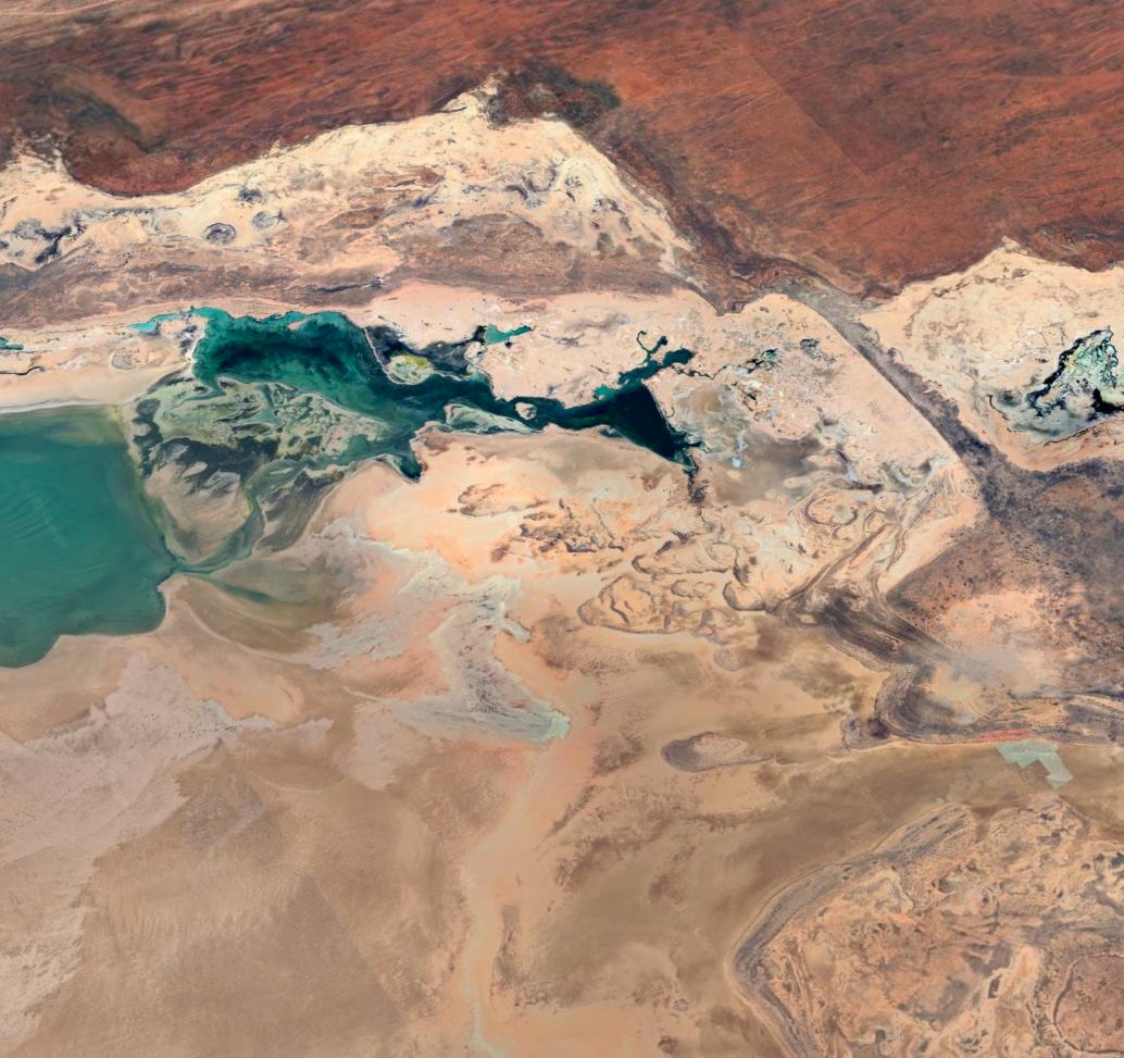 Vista aérea del paisaje desértico en Australia Occidental, capturada por Google Earth, donde contrastan las lagunas turquesa con las formaciones rocosas y los tonos ocres del terreno. FOTO cortesía Google Earth