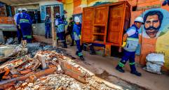Con apoyo de los funcionarios de la Alcaldía de Medellín, las familias desalojadas sacan sus pertenencias y las llevan en camiones a bodegas o a las casas donde se van a albergar. FOTO JULIO CÉSAR HERRERA