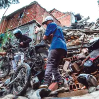 Así quedaron las viviendas luego del colapso estructural en el barrio La Cruz. Los dueños de las motos afectadas intentaron recuperarlas entre los escombros. FOTO JULIO CÉSAR HERRERA