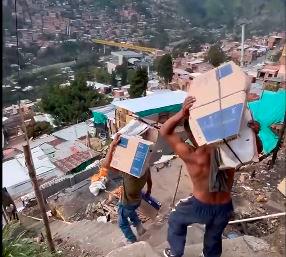 Las personas ayudaron a cargar los nuevos elementos para las casas. Foto: Captura de video. 