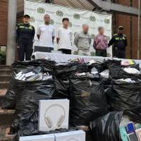 En las bolsas negras, todos los celulares y artículos recuperados e incautados. Al fondo, los cuatro capturados en el Opera. FOTO Policía Metropolitana. 