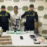 El capturado en Barrio Antioquia junto con la marihuana que fue incautada en la propiedad que servía como acopio ilegal. FOTO Policía Metropolitana. 