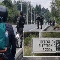 Adelante, el afiche dejado por las Disidencias. Atrás, las autoridades hacen el cierre preventivo de la vía. FOTO: Cortesía Denuncias Antioquia
