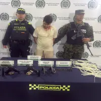 Adelante, parte de las armas encontradas por las autoridades. Atrás, uno de los detenidos. FOTO: Cortesía