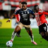 El lateral colombiano Léyser Chaverra, del DIM, y el extremo vallecaucano Edwuin Cetré, de Estudiantes, disputan un balón en el estadio de La Plata, en Argentina. Foto: AFP