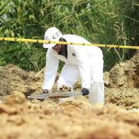 Los investigadores judiciales se encargaron de hacer las labores correspondientes con los restos óseos hallados en un sendero rural de Envigado, a más de 3 horas de la zona urbana. FOTO: EL COLOMBIANO