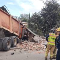 La volqueta que al parecer llevaba material impactó contra la infraestructura de una empresa de la zona identificada como J.M. Estrada. FOTO: Bomberos La Estrella