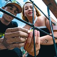 David Mesa y Jeimy Montoya, en el momento en que realizaban el ritual del candado en el Puente de Occidente. Lo hicieron a hurtadillas, como si temieran ser castigados. FOTO Julio César Herrera