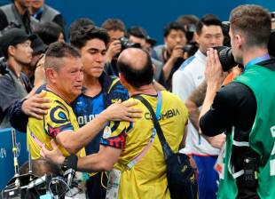 Jairo Ruiz llora mientras abraza a Ángel Barajas, tras conocer el resultado de la medalla de plata para el país. FOTO CORTESÍA COC 