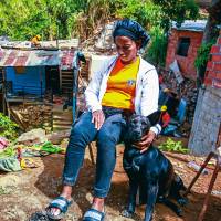 Marcelina Valencia está al lado de su perra, sentada en una silla, viendo cómo funcionarios de la Alcaldía tumban su vivienda y la de su hermano. FOTO: JULIO CÉSAR HERRERA