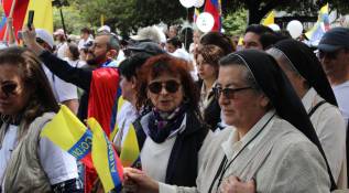  El rostro de Miguel Uribe impreso en carteles estuvo presente en las manos de cientos de asistentes. Foto: Loren Buitrago