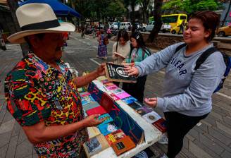 Heriberto Piedrahíta vende libros en la acera del edificio Gualanday, subiendo hacia el Mimos de La Playa. Instala el negocio antes de las 7:00 y extiende los libros uno tras otro a la vista de los transeúntes. FOTOS Manuel Saldarriaga