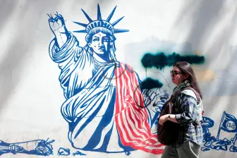 Una mujer camina junto a un mural antiestadounidense cerca de la antigua embajada estadounidense en Teherán. FOTO ATTA KENARE / AFP