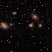 Imagen de DECam de un campo en la constelación austral de Lepus que muestra estrellas de la Vía Láctea (pequeños puntos de colores) y un grupo de galaxias (los objetos difusos de mayor tamaño) situado a unos 300 millones de años luz. FOTO Agencia SINC - Erin Sheldon