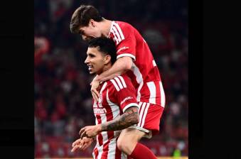 El colombiano Gustavo Puerta celebra con uno de sus compañeros en la victoria del Olympiacos en el clásico griego. FOTO TOMADA X@olympiacosfc