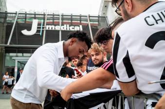 El defensor colombiano Juan David Cabal firmando algunas camisetas, tras su presentación como nuevo jugador de Juventus. FOTO TOMADA @JUVENTUSFC