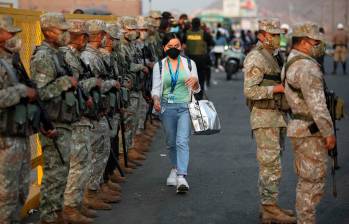 Militares y policías controlan un paradero de transporte público en Lima. FOTO: EFE