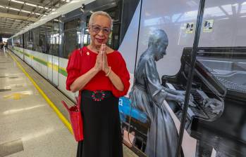 Teresita Gómez posa al lado de su Tren de la Cultura, ese lleno de imágenes suyas y reflexiones para acompañar a los viajeros del Metro de Medellín. FOTO Manuel Saldarriaga. 