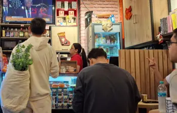 Miles de venezolanos que residen y trabajan en Medellín siguen a través de establecimientos comerciales la captura del dictador Nicolás Maduro. Foto: EL COLOMBIANO